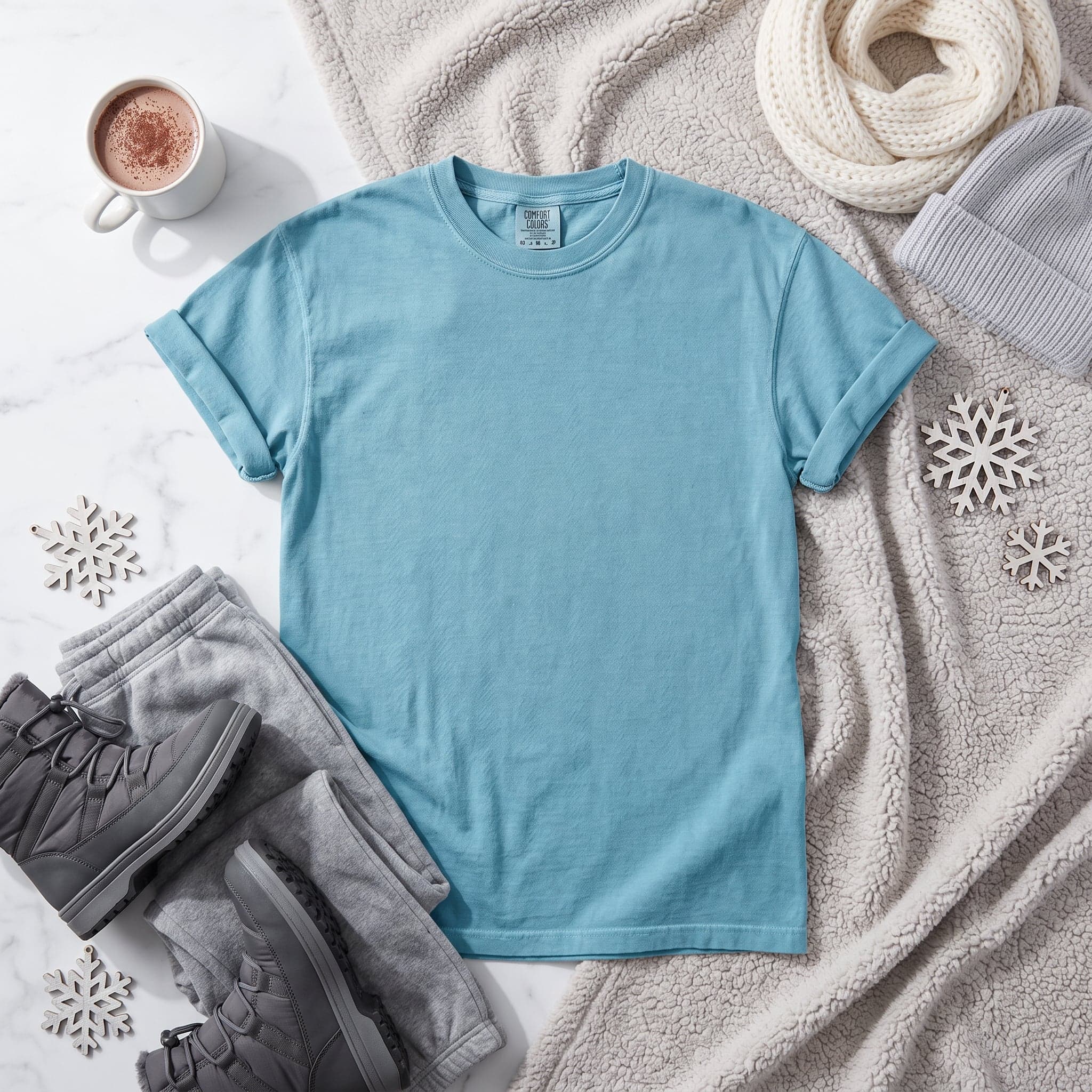 Comfort Colors 1717 t-shirt mockup in Ice Blue — winter-themed flat lay shot, chest panel left clean
